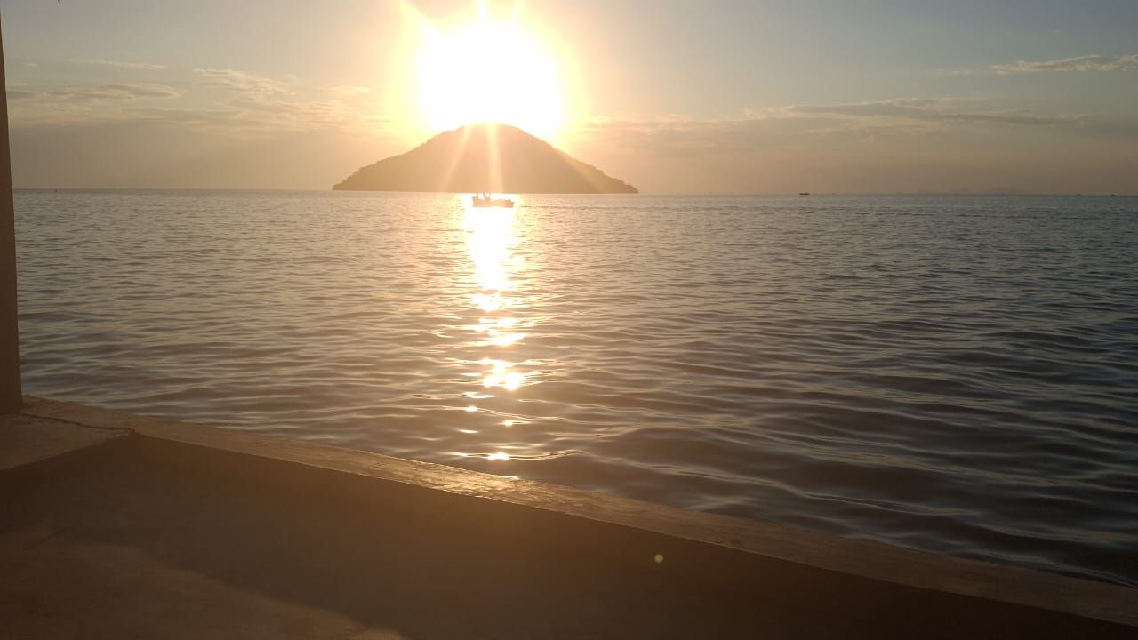 A body of water with a distant landmass and a boat.