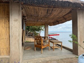 A covered outdoor seating area with a view of the water. - Anake Lodge (Cape Maclear)