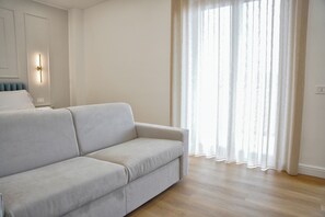 Quarto quádruplo luxo, 1 cama Queen e sofá-cama, banheiro privativo | Área de estar