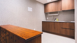 A kitchen with wooden cabinets, a countertop, and a wooden table.