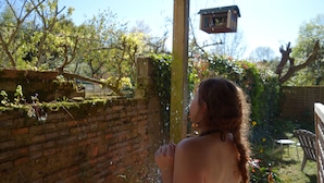 A person standing in a garden with a brick wall and a wooden pergola. - House with river access and sauna at the foot of the château, La Flèche zoo and 24h (Durtal)