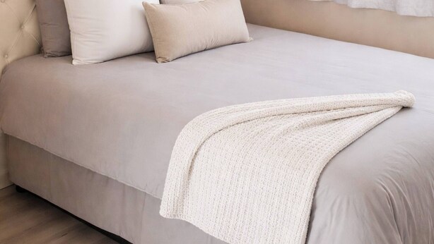 A bedroom with a tufted headboard, a bed with white bedding, a white throw blanket, and a window with sheer curtains. - Cozy Private Studio Flat in Westdene, Johannesburg (Johannesburg)