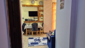 A hallway with a dining area, a sofa, and a patterned rug. - Star Apartment 2 Hurghada (Hurghada)
