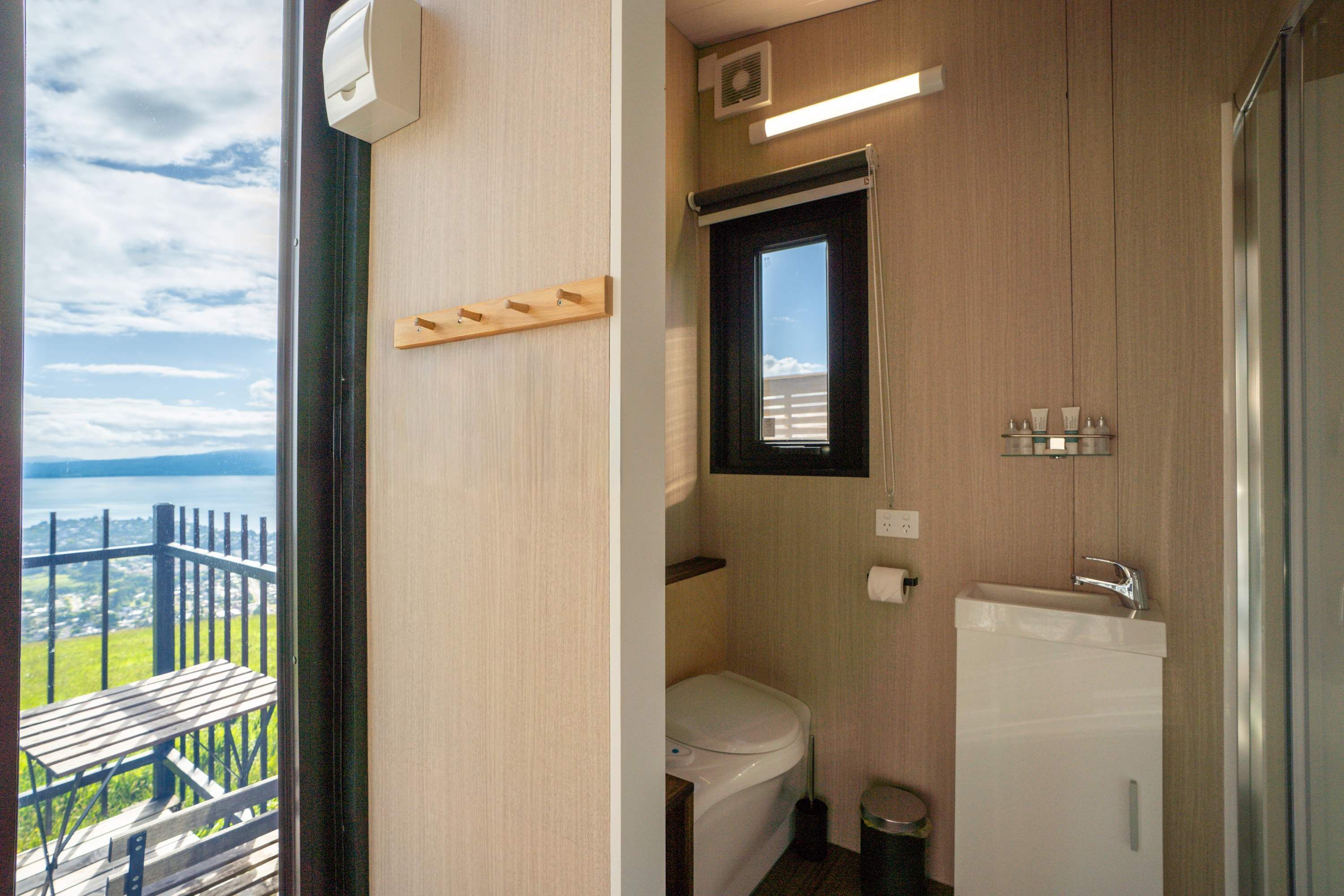 Ein kleines Badezimmer mit Toilette, Waschbecken und Fenster.