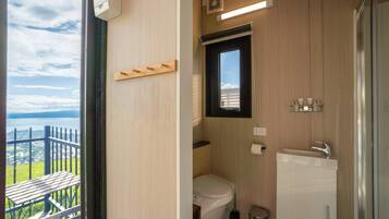 Ein kleines Badezimmer mit Toilette, Waschbecken und Fenster.
