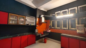 A kitchen with red cabinets, a gas stove, and a range hood.