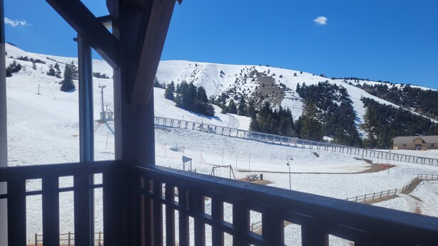 A snow-covered mountain landscape with a ski lift and a wooden structure in the foreground. - Cosy apartment, superb view at the foot of the slopes. (Selonnet)