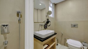 Un baño con ducha, inodoro, lavabo y espejo.