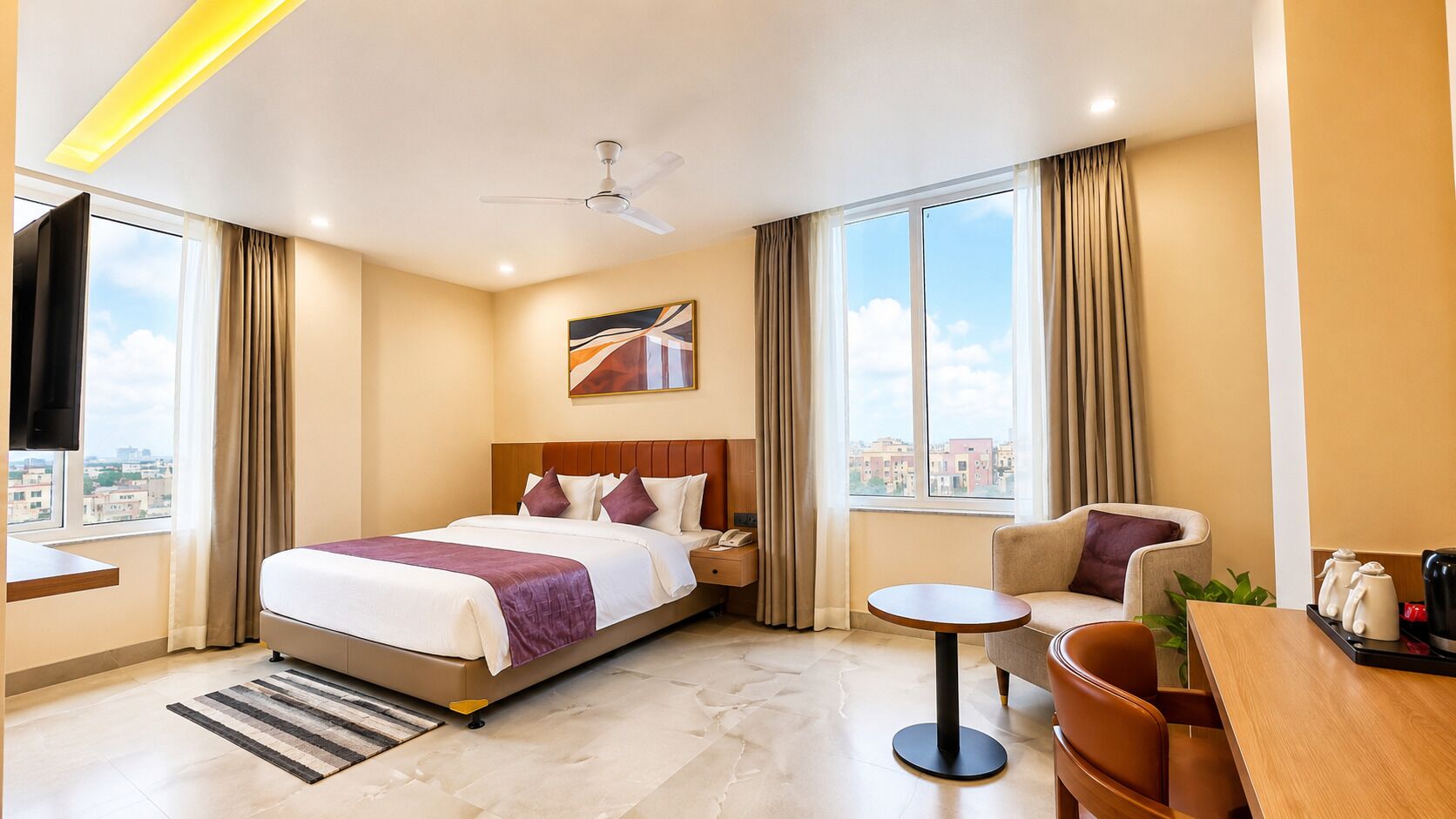 Habitación de hotel con cama, sofá, una mesita, estación de café y vistas a la ciudad.