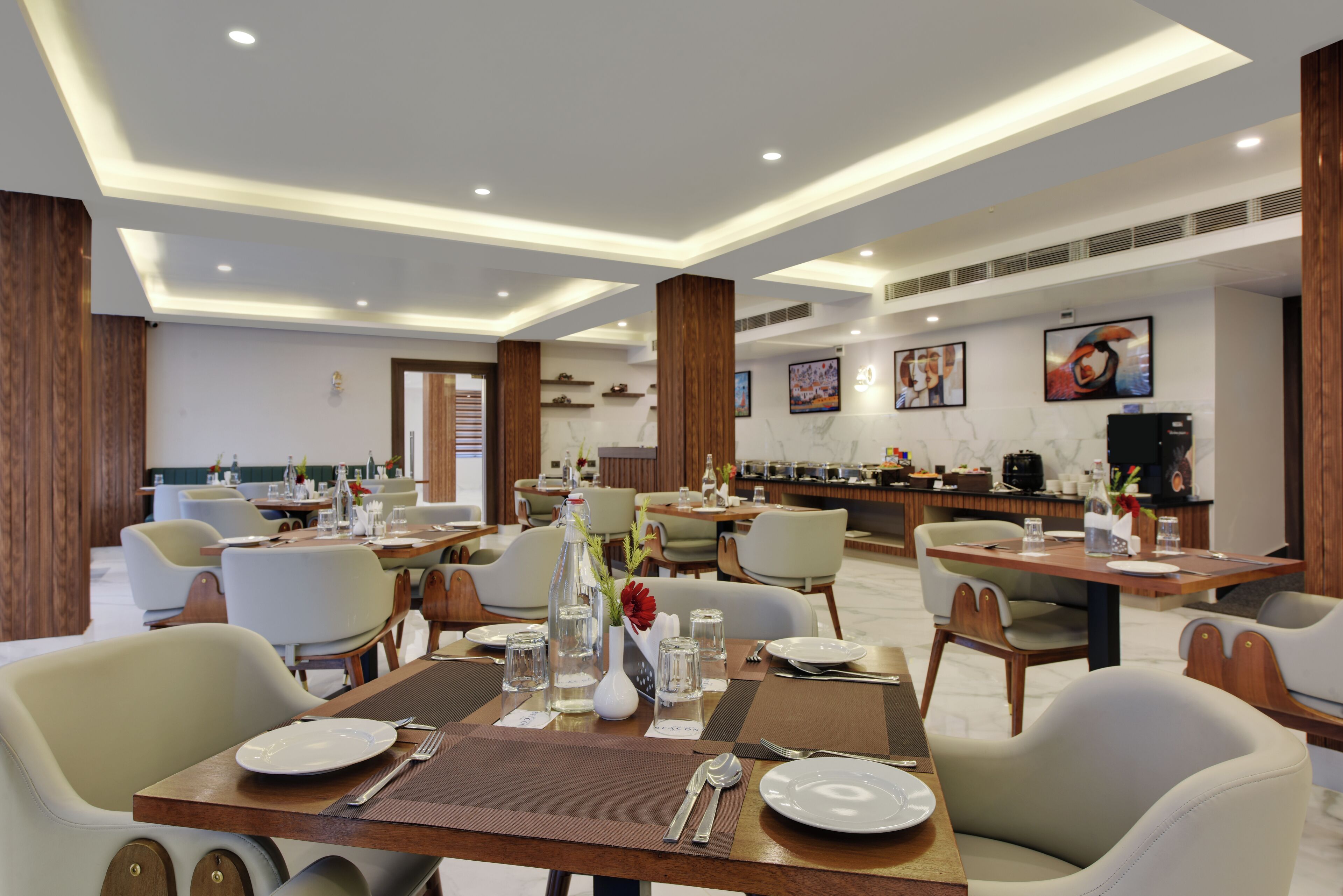 A modern dining area with multiple tables, chairs, and a buffet setup.