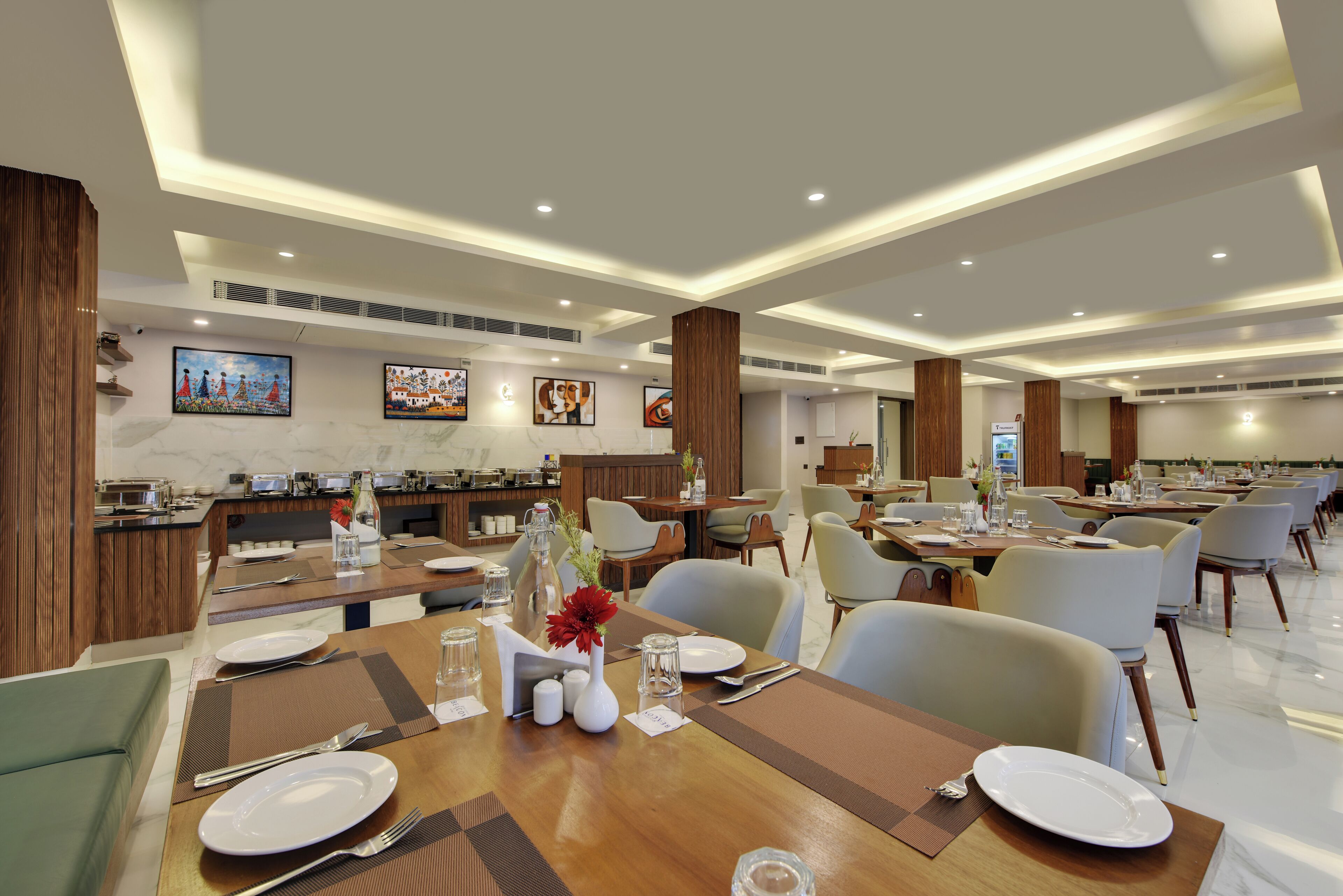 A modern dining area with multiple tables, chairs, and a buffet setup.