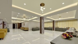 A spacious hotel lobby with a marble floor, seating areas, and a reception desk. - Vaishnavi Beacon Hotel Patna (Patna)