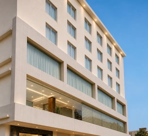 Ein mehrstöckiges Hotel mit großen Fenstern, einer glatten Fassade und modernem Design.