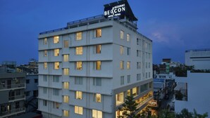 Un hotel de varios pisos con un letrero llamativo que dice 'Beacon Hotel - Patna'.