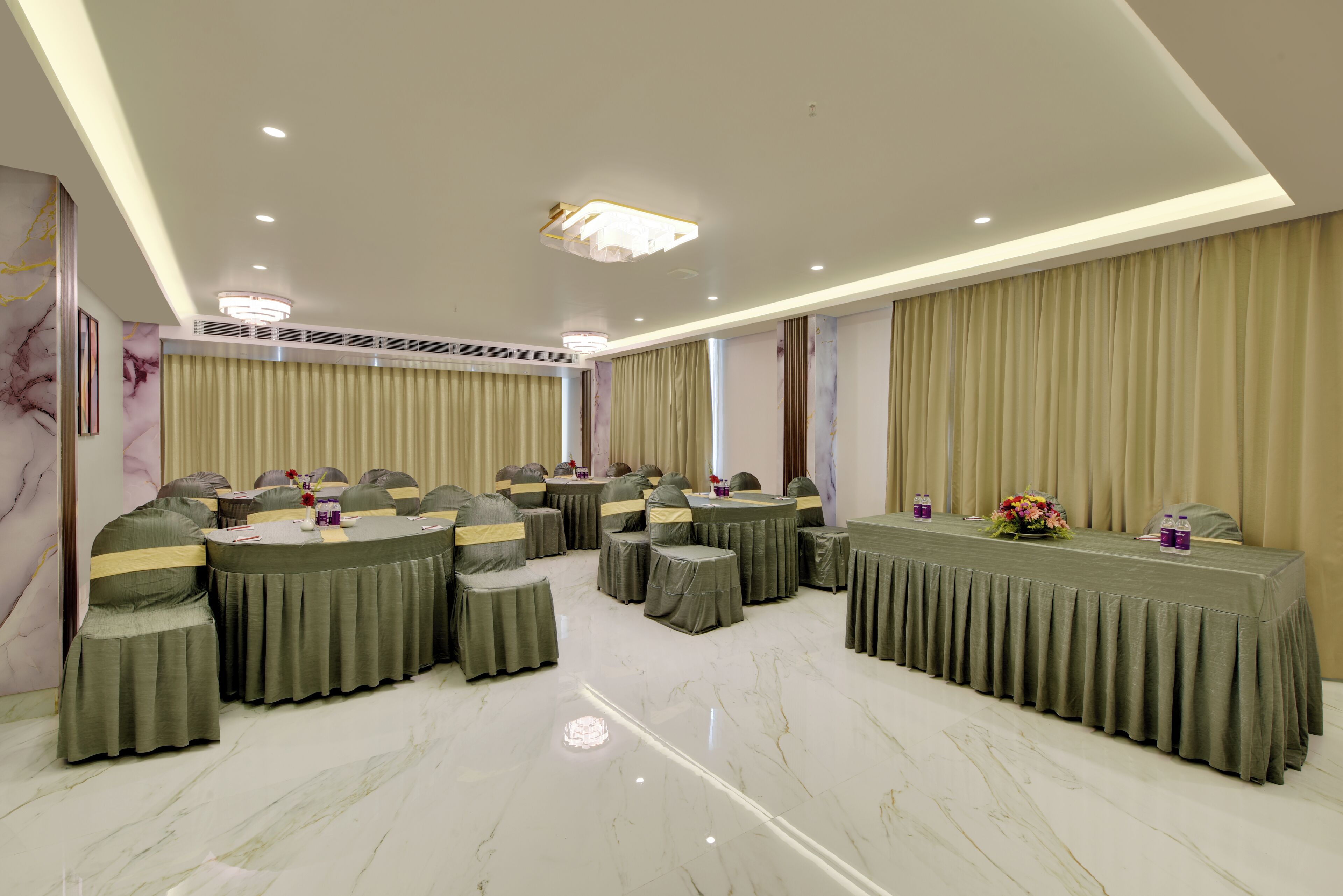 Un salón de conferencias con mesas redondas, sillas y piso de mármol.