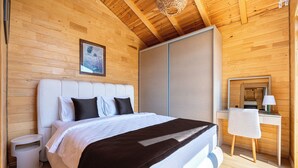 Una habitación con paneles de madera, una cama, un escritorio y una silla.