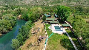 Un complejo turístico con varias cabañas, una piscina y un río.