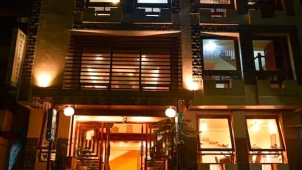 A multi-story building with a traditional architectural style, featuring a central entrance with steps, multiple windows, and a visible balcony on the upper floors. - Hotel Bella Casa (Gangtok)