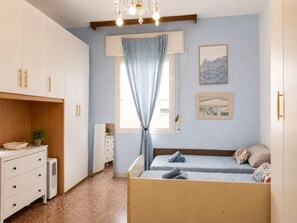 A bedroom with a bed, a dresser, a mirror, and a window with curtains. - Bed and Breakfast Near Unipol Arena (Casalecchio di Reno)