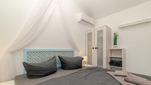 A bedroom with a bed, a nightstand, a wardrobe, and an air conditioning unit. - Apartment 'Sole-mare' with Sea View, Wi-Fi and Air Conditioning (Porto Ottiolu)