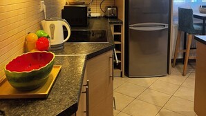 A modern kitchen with a stainless steel refrigerator, a kettle, and a microwave. - Bright & Elegant Apartment - Comfort & Style in Piraeus (Pireas)
