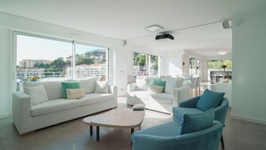 Un salon moderne comprenant un canapé, des fauteuils, une table basse et un coin repas avec des chaises et une table.