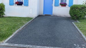 A building with a blue door, two windows with blue shutters, and flower boxes. - House for rent Audierne (Audierne)