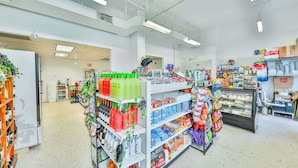 A supermarket aisle with shelves stocked with beverages, snacks, and household items. - Bright & Spacious 3BR Pool Retreat | Near Beach! (Sunny Isles Beach)