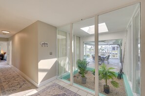 A hallway with a welcome sign, a glass door leading to an outdoor patio with plants and fishing rods. - 4-bedroom Water front Home w/Heated Pool in Punta Gorda Boating, fishing
sleep10 (Punta Gorda)