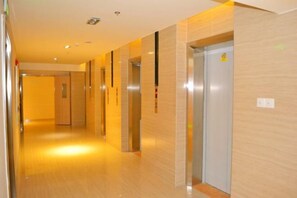 A corridor with elevators and a door at the end. - SilkStay Apartment Chengdu Kuanzhai Alley (Chengdu)