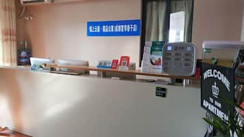 A reception desk with a blue sign, a water dispenser, and a welcome sign.
