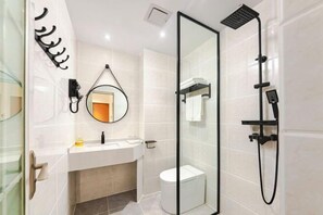 A modern bathroom with a glass shower enclosure, a white sink, and a mirror with a round frame. - SilkStay Apartment Chengdu Kuanzhai Alley (Chengdu)