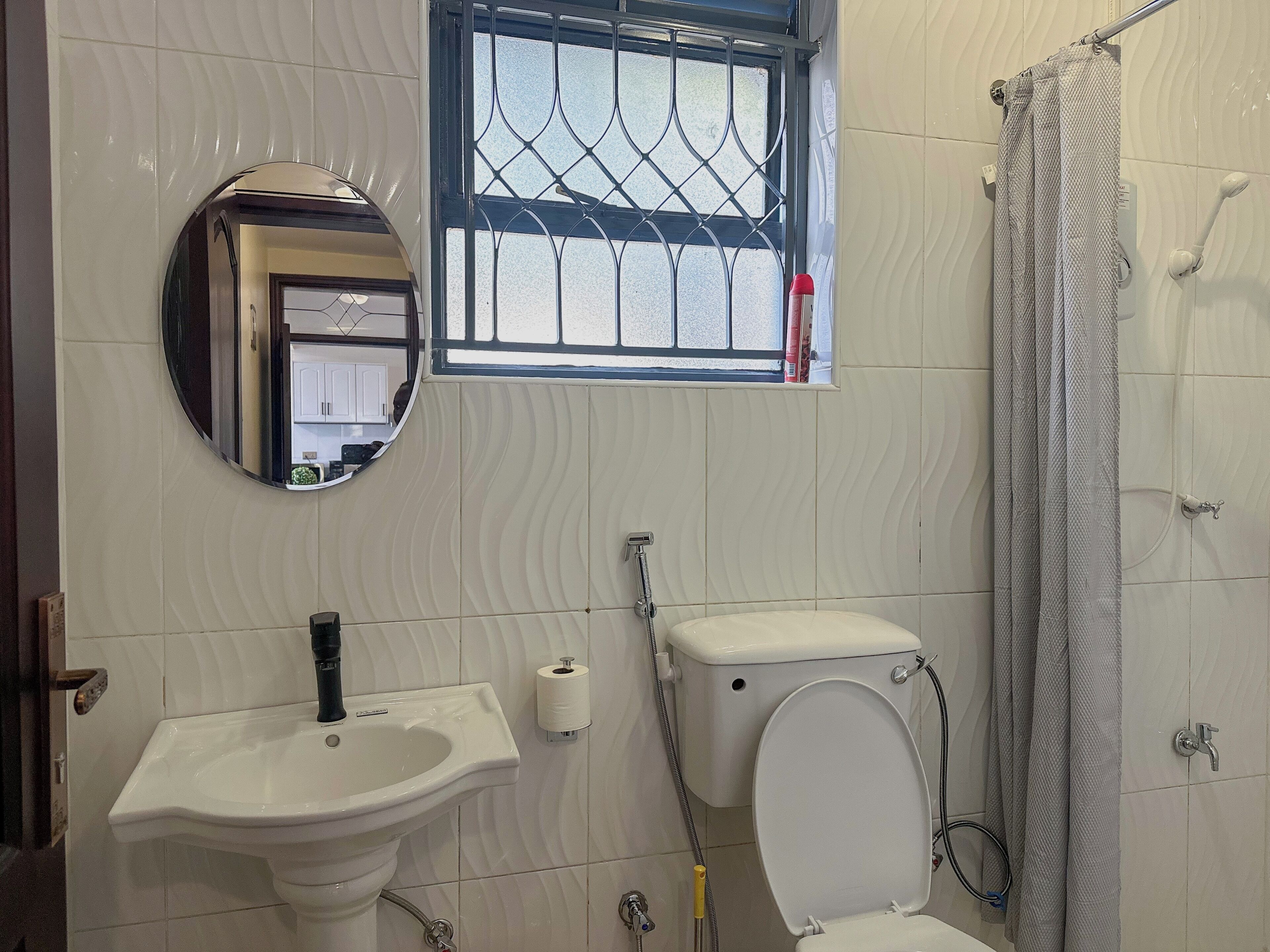 A bathroom with a toilet, sink, and shower curtain.