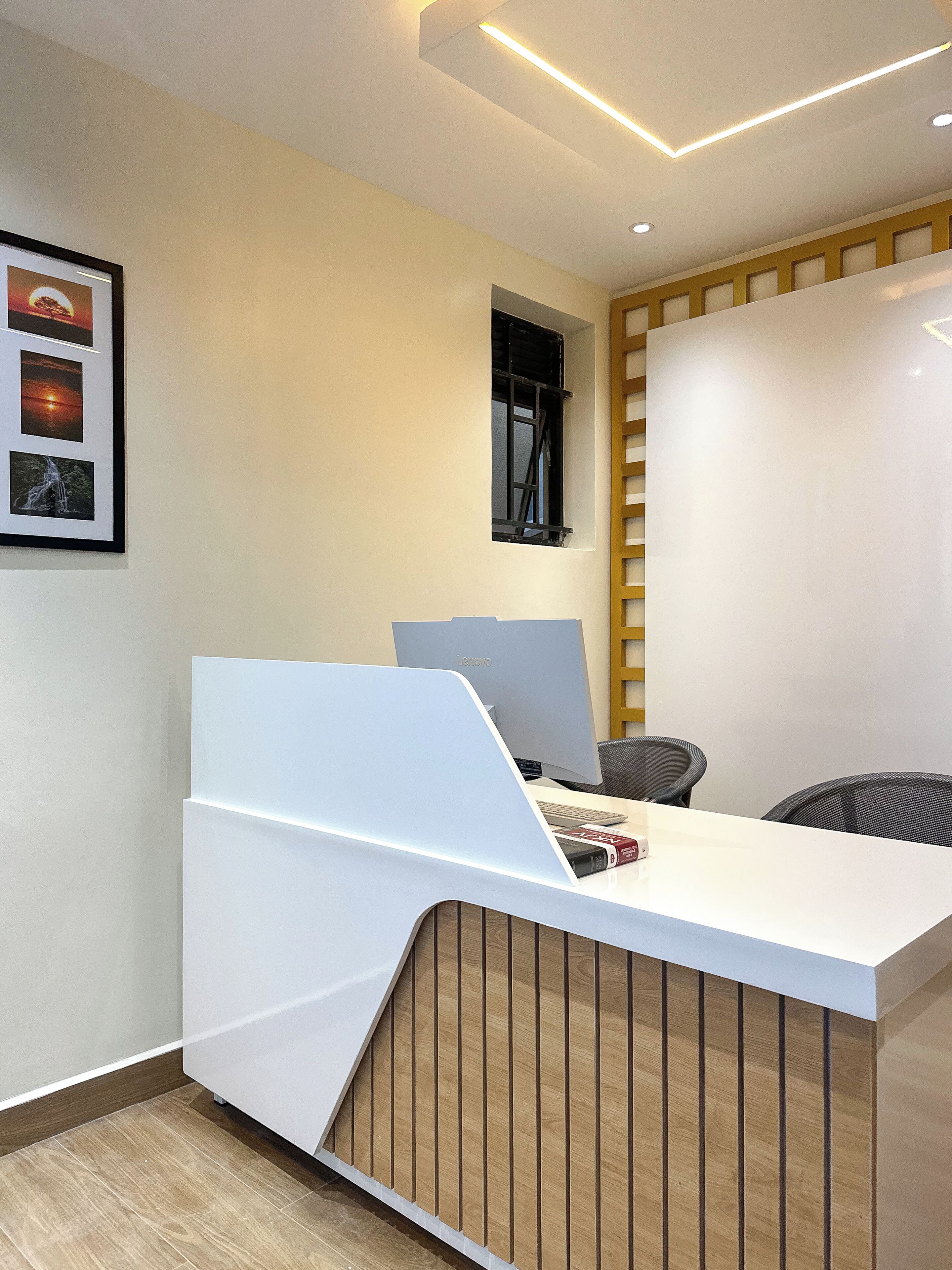 A modern office space with a white desk, computer, and chair.