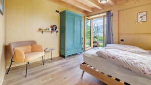 Een kamer met een bed, een slaapbank, een kast en een klein tafeltje.