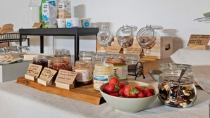 Diverse soorten etenswaren en sauzen, gepresenteerd op een tafel met labels.