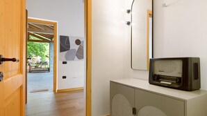 Una habitación moderna con una puerta de madera, un mueble con una radio y un espejo en la pared.