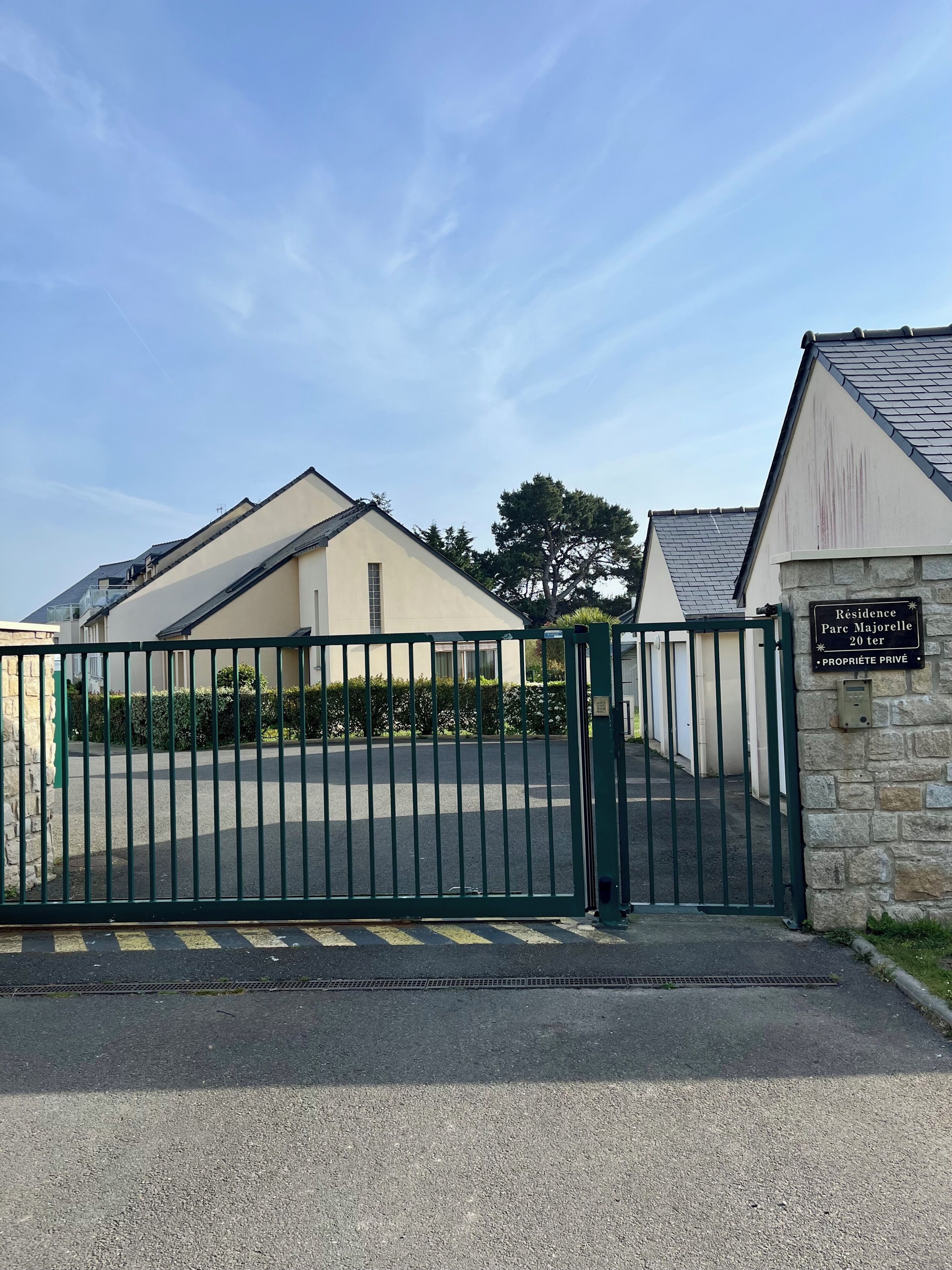 Une entrée fermée par un portail donne accès à un quartier résidentiel, bordé d’un mur en pierre et agrémenté d’un panneau indiquant : « Résidence Parc Majorelle 20 ter – PROPRIÉTÉ PRIVÉE ».