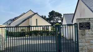 A gated entrance to a residential area with a stone wall and a sign indicating 'Residence Parc Majorelle 20 ter PROPRIETE PRIVÉE.' - Apartment in quiet, secure residence (Paimpol)
