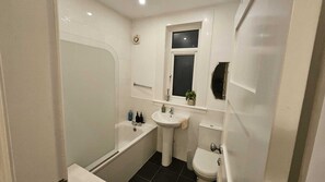 Een haardroger, handdoeken, zeep, toiletpapier