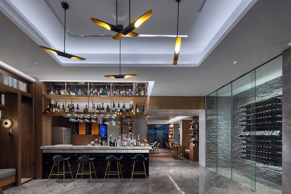 A modern bar area with a high ceiling, pendant lighting, and a wine cellar. - ECHIC Mercure International Hotel Guangzhou Railway Station Xiaobei Metro Station Branch  (Guangzhou)