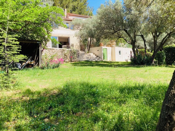 Une maison avec un mur en pierre, une porte verte et un petit balcon.