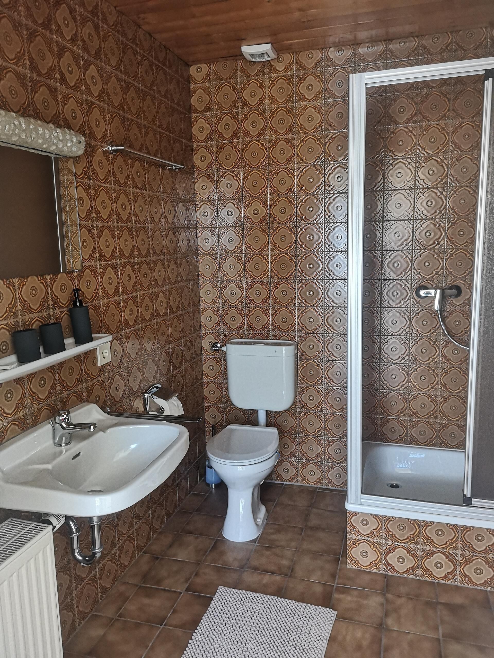 Un baño con lavamanos, inodoro y ducha.