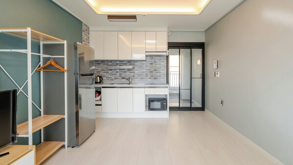 A modern kitchen with a built-in oven, a microwave, and a coffee maker.