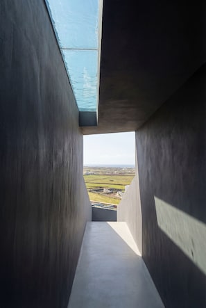 Un pasillo con vistas a un paisaje a través de una estructura de concreto.