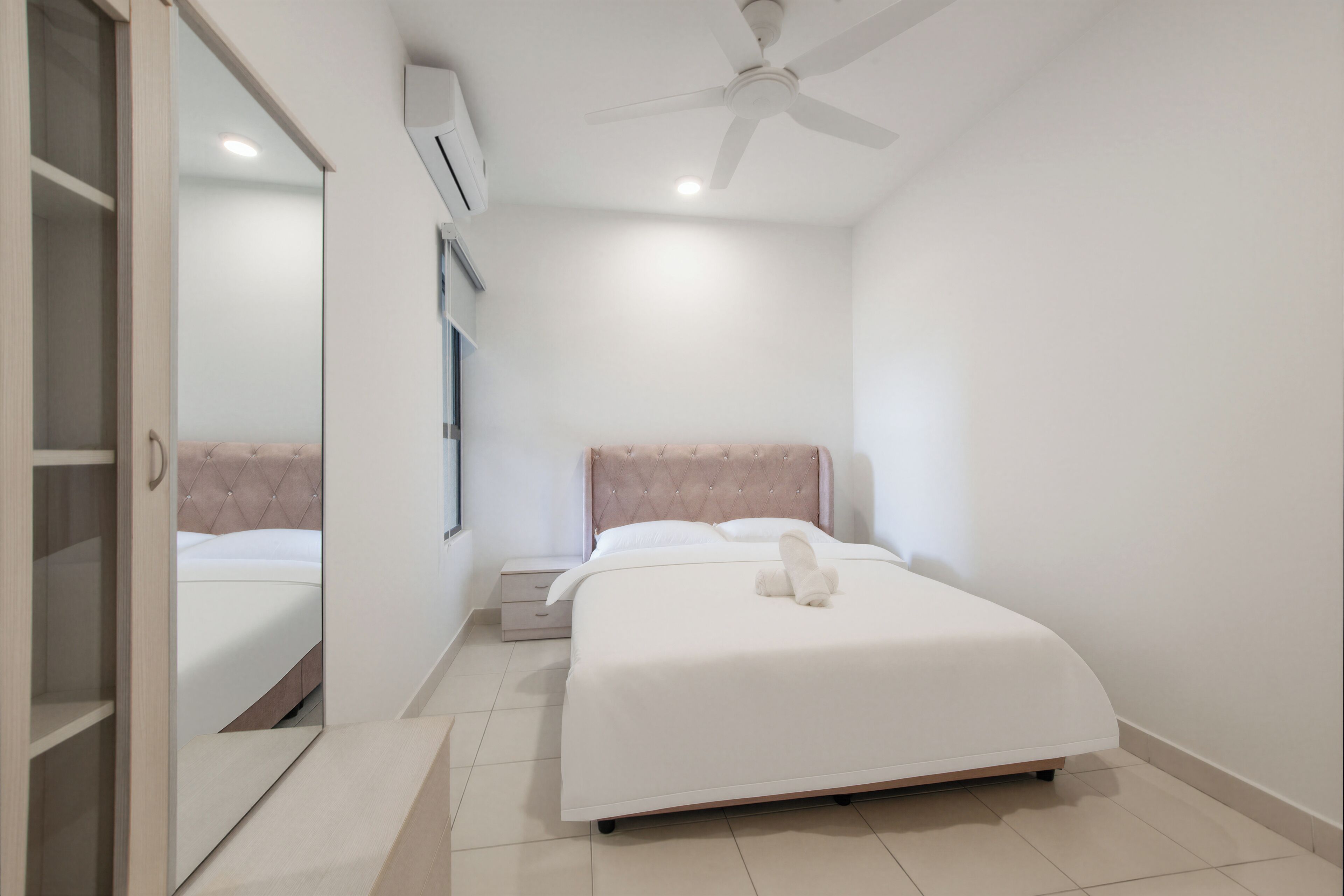 Un dormitorio con cama, ventilador de techo, mesita de noche y armario.