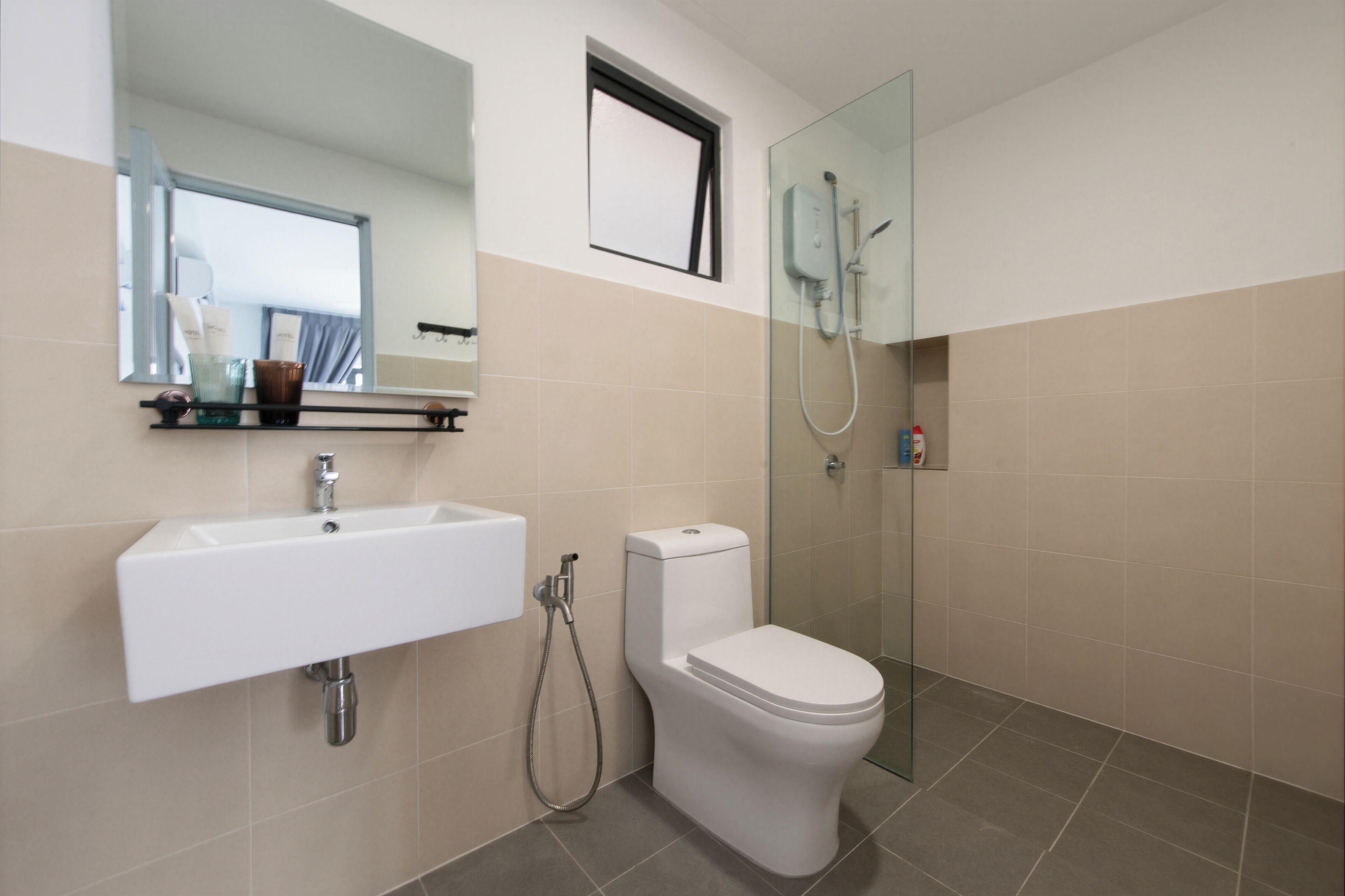 A bathroom with a white sink, toilet, and glass-enclosed shower.