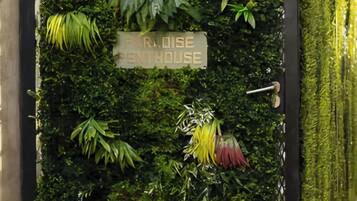 A vertical garden wall with a sign reading 'REPUBLIC HOUSE' and a metal gate.