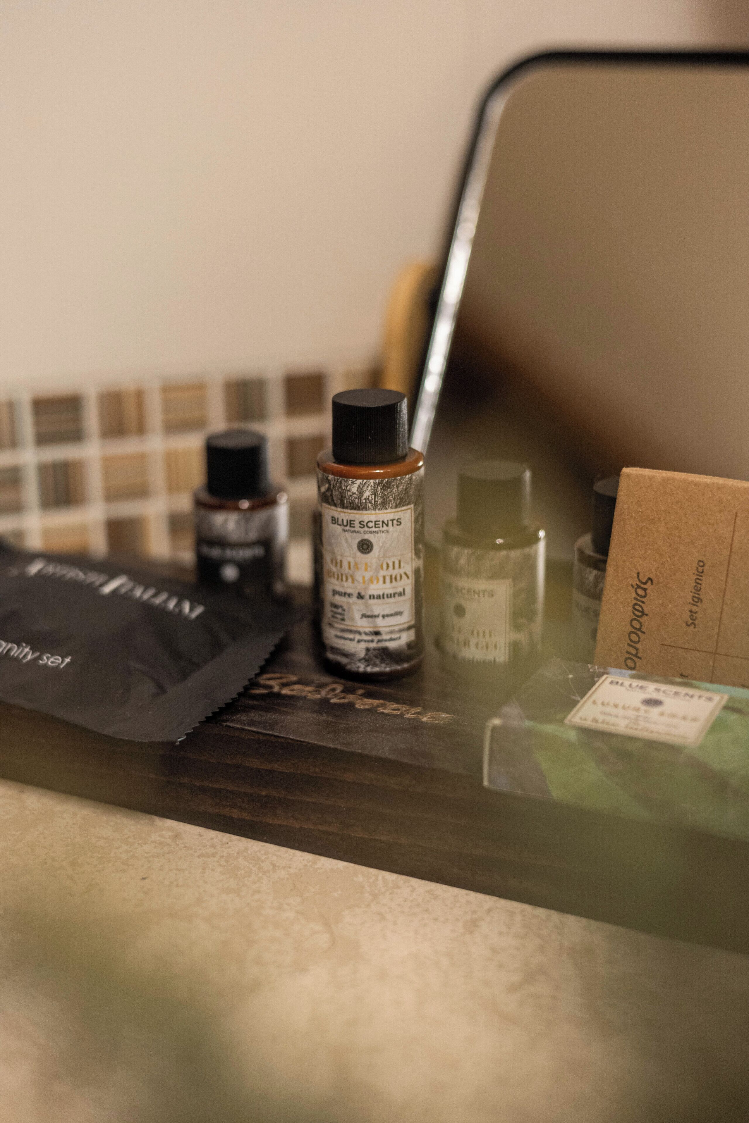 Eine Arbeitsfläche mit verschiedenen Flaschen Blue Scents Olivenöl-Körperlotion und anderen Körperpflegeprodukten.