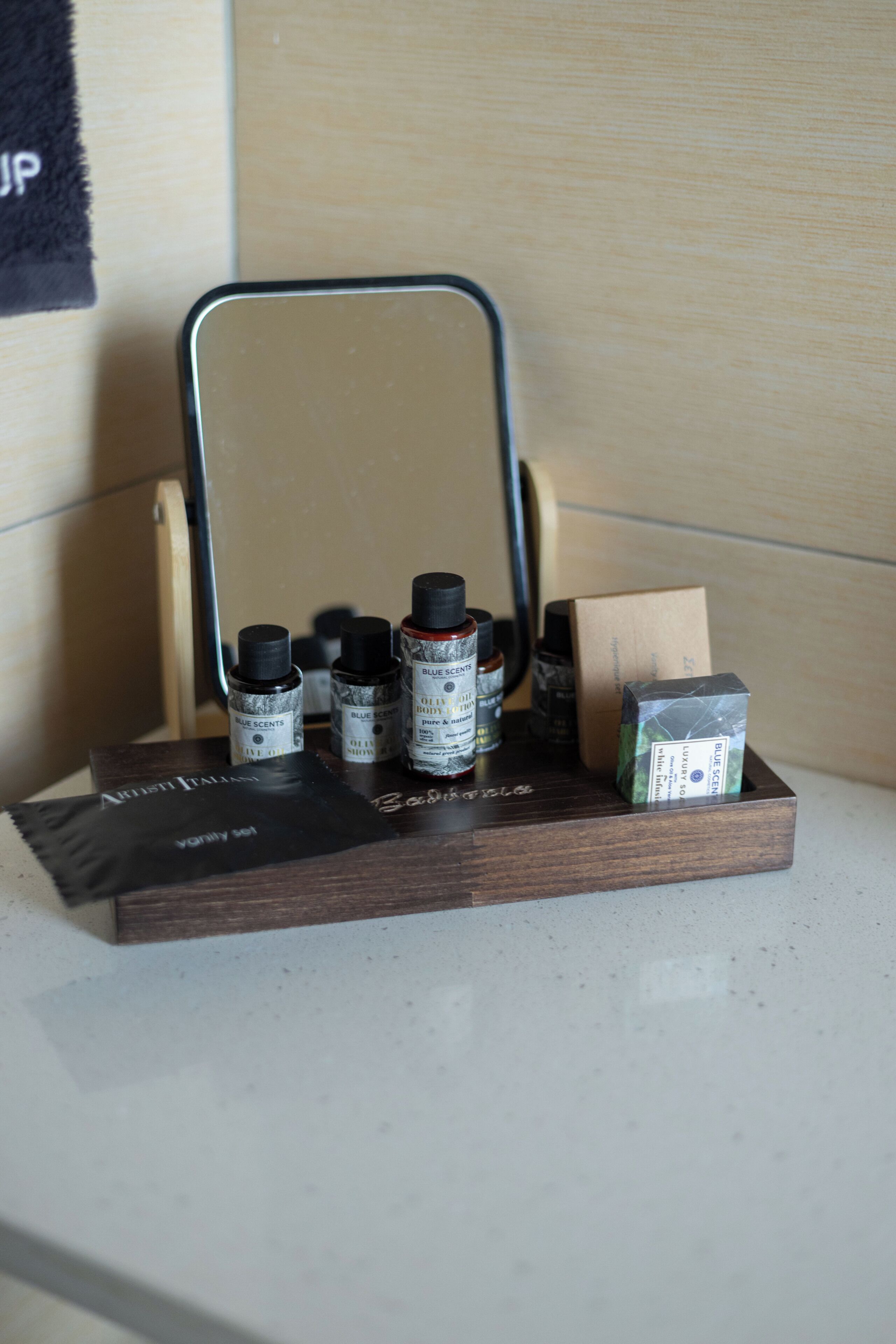 A wooden shelf with various bottles and a mirror.